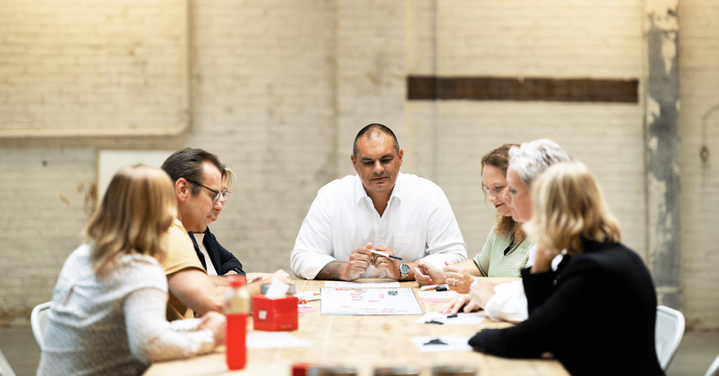 overleg groep werknemers aan tafel, vx company